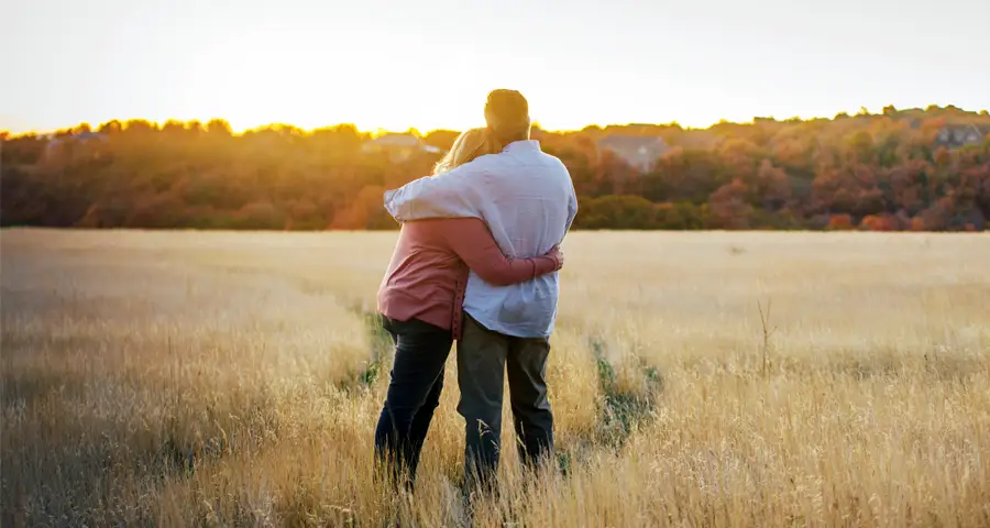 una pareja se abraza al atardecer
